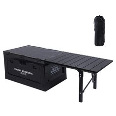 a black table with two storage boxes underneath it and a bag next to it on the side