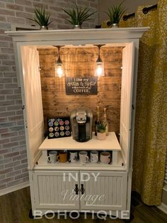 a small coffee shop with lots of items in the cupboards and lights above it