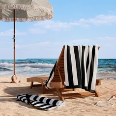 a beach chair and umbrella on the sand