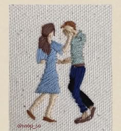 an embroidered picture of two people holding hands