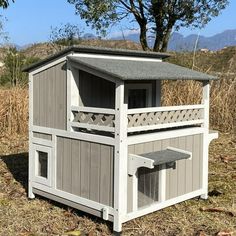 a small wooden dog house in the middle of a field