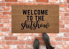 someone standing in front of a door mat that says welcome to the shitshow