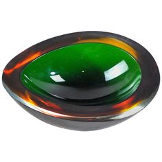 a green and brown glass bowl sitting on top of a white table