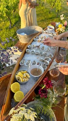 people standing around a table filled with food and drinks