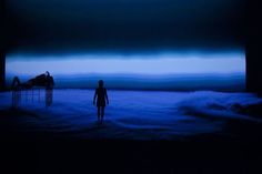 a person standing in the middle of a room with dark clouds and blue sky behind them