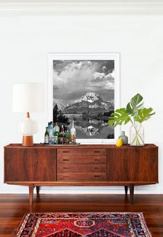 a living room with a large rug and a wooden dresser