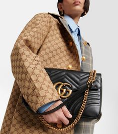 Find GUCCI Gg Marmont Shoulder Bag on Editorialist. This Gucci GG Marmont shoulder bag is crafted from calf leather with a quilted chevron design. The bag has a magnetic closure, adjustable shoulder strap, and a suede lining. It is made in Italy and features the iconic Gucci logo on the front. Gucci Quilted Leather Shoulder Bag, Gucci Top Handle Shoulder Bag For Work, Luxury Gucci Bags For Work, Gucci Quilted Formal Shoulder Bag, Gucci Luxury Shoulder Bag For Work, Designer Gucci Quilted Bags, Gucci Designer Shoulder Bag For Business, Gucci Bags With Detachable Strap For Work, Designer Gucci Shoulder Bag For Business