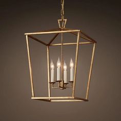 a light fixture with three lit candles hanging from it's center and two smaller ones in the middle