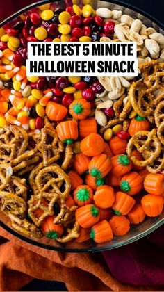 a platter filled with candy corn, pretzels and pumpkins