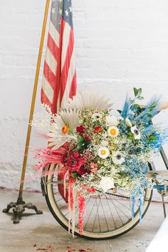 an american flag and flowers on a bike