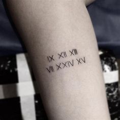 a woman's arm with roman numerals tattoo on the back of her leg