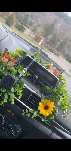 a car dashboard with flowers and butterflies on the dash board, along with an mp3 player