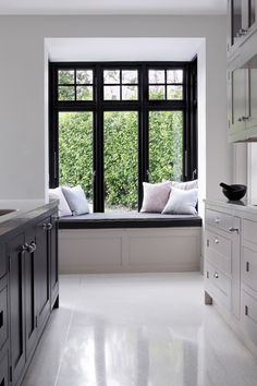 a window seat in the middle of a kitchen next to a sink and counter top