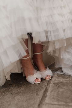 the bride's shoes are all white and have ruffles on them,