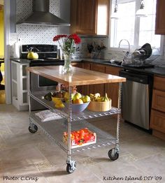 a kitchen island cart with fruit and vegetables on it