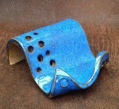 a blue ceramic object with holes in it