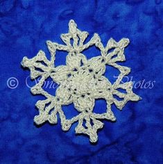 a white snowflake is on a blue cloth with the word, christmas written in it