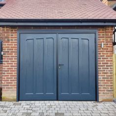 two blue garage doors in front of a brick building