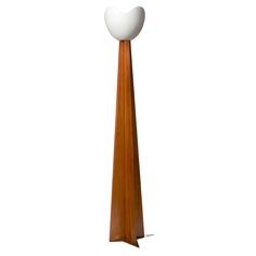 a tall wooden floor lamp with a white ball on top