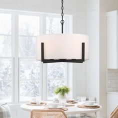 a dining room table with chairs and a light fixture hanging from it's ceiling