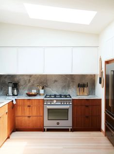 a kitchen with wooden cabinets and stainless steel stove top oven in the middle of it