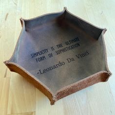 a ceramic bowl with writing on it sitting on top of a hard wood flooring