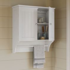 a white cabinet with towels hanging from it's sides