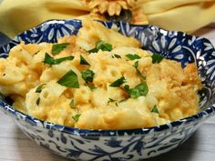 a blue and white bowl filled with macaroni and cheese