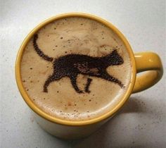 a coffee cup with a cat drawn on the foam in it's cappuccino