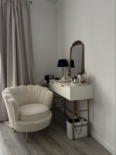 a white chair sitting in front of a desk with a mirror on top of it