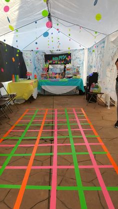 a woman standing in front of a table with colorful streamers on it