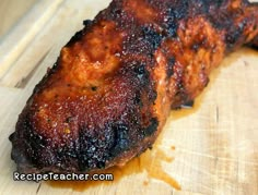 a piece of meat sitting on top of a wooden cutting board