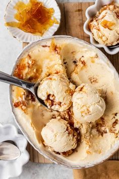 two bowls filled with ice cream on top of a wooden table next to spoons