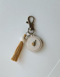 a keychain with a tassel hanging from it's side on a white surface