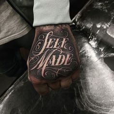 a man's hand with the words self made tattooed on it