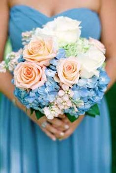 a bridesmaid holding a bouquet of flowers in her hands and wearing a blue dress