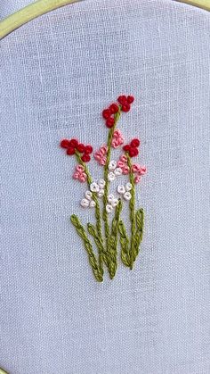 a close up of a piece of cloth with flowers embroidered on the front and back