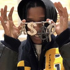 a person holding their hands up to their face with chains attached to the top of them