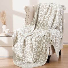 a white and gray blanket sitting on top of a chair