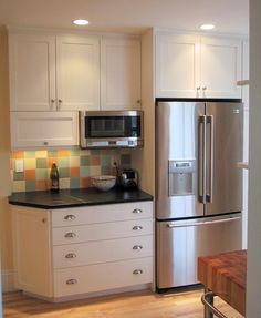 a kitchen with white cabinets and stainless steel appliances