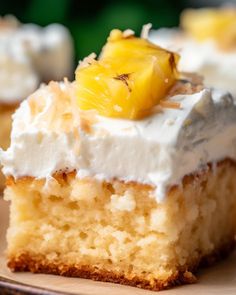 a piece of pineapple poke cake with whipped cream and pineapple slices on top