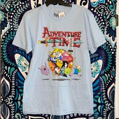 an adventure time t - shirt hanging on a wall