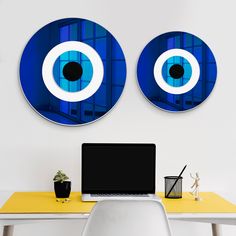 a laptop computer sitting on top of a desk next to two large blue eyeballs