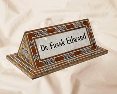 a sign that reads dr frank edward on the front and side of it with an ornate border