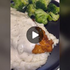 a blue plate topped with meat and gravy next to broccoli