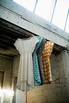 clothes hanging from a line in an old building with exposed ceiling and windows above them