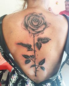 a woman with a rose tattoo on her back