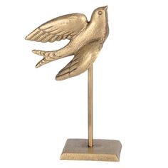 a gold bird statue on a metal stand