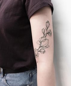 a woman's arm with a flower tattoo on the left side of her arm