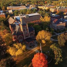 an aerial view of a campus with trees and buildings in the fall colors, from above